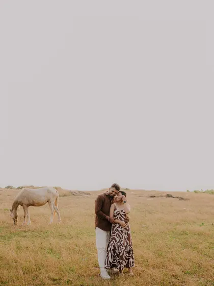 A stunning wide shot that captures the couple in a vast, open landscape. The minimalist composition makes their embrace the central focus of this epic, romantic scene.