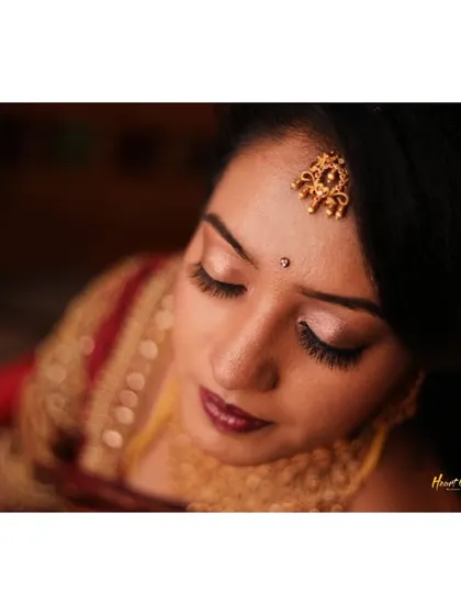 A close-up shot capturing the bride's peaceful expression and beautiful traditional jewelry.