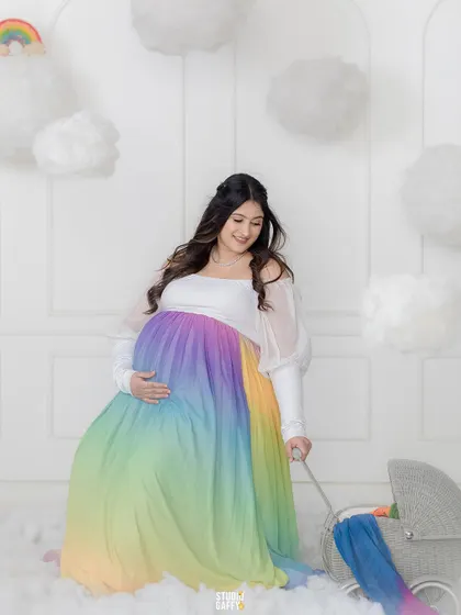 A solo portrait of the mother-to-be in a flowing rainbow gown, surrounded by clouds. This shot emphasizes her grace and the magical journey she is on.