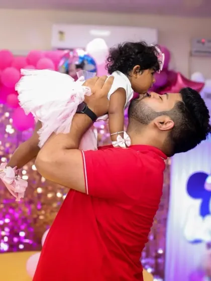 A father lifts his daughter in the air, sharing a kiss during her birthday celebration. These are the candid, emotional moments we aim to capture throughout your event.