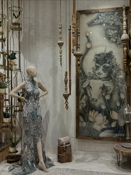 A glimpse into a designer's store, where fashion meets art. This mannequin is styled in a stunning gown next to a beautiful piece of artwork, showing the creative synergy I love.