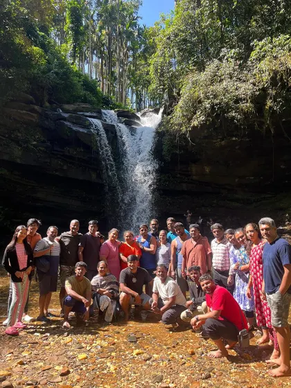 A large group photo in front of a beautiful waterfall, a highlight of our Netravathi weekend trip.