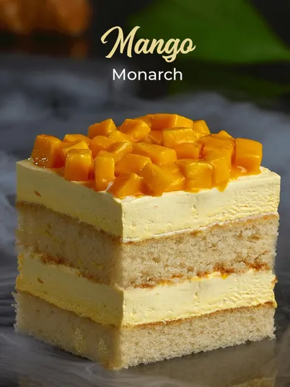 Our Mango Monarch ice cream cake slice. Layers of sponge and mango ice cream, topped with fresh mango chunks, make this an irresistible summer treat.