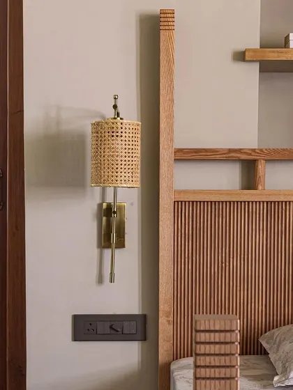 A close-up of a custom bed and rattan wall sconce in Apartment 5026. We often use natural, tactile materials to bring warmth and a human touch to our interiors.