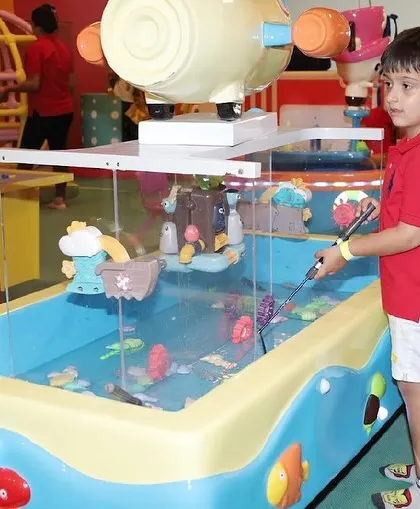 A boy tries his hand at the magnetic fishing game, a fun challenge for developing coordination.