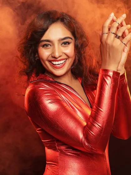 A joyful and energetic shot from the same series, capturing a beautiful, genuine smile. The warm, smoky background adds to the vibrant and happy mood.