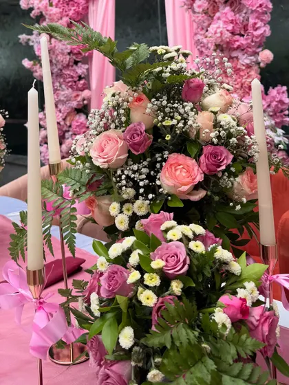 A detailed shot of the pink floral arrangements and taper candles that adorned the tables at the bow-themed event.