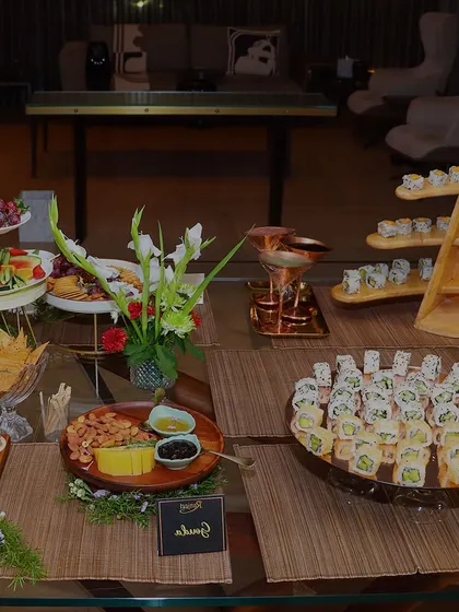 A complete grazing table setup for a corporate soiree. This spread includes a variety of options from sushi to cheese boards, designed for social interaction and sophisticated snacking.