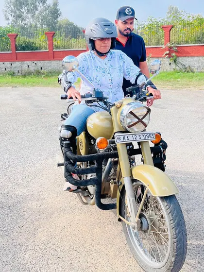 Guiding a student as she practices maneuvering the bike. My constant presence ensures safety and provides immediate feedback to correct and improve her technique.