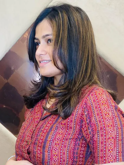 A happy client with a new layered haircut and subtle highlights. The color adds depth to the layers and frames her face beautifully.