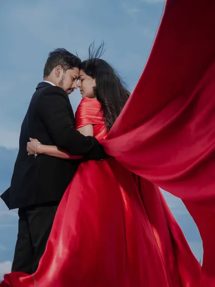 A dramatic and artistic pre-wedding photo. We love getting creative with concepts, using elements like flowing fabrics and stunning landscapes to create fine art portraits you'll treasure forever.