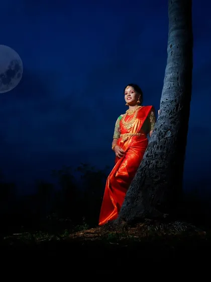 A creative shot from a Pongal night celebration. The model is wearing a traditional pattu saree and a full temple jewellery set, all available for rent.
