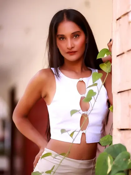 A beautiful portrait using natural elements to frame the shot. The green leaves add a touch of organic beauty to her modern look.