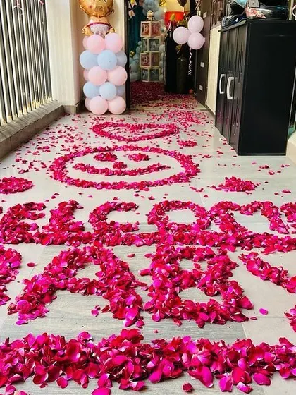 A creative "Welcome Baby" message written with rose petals on the floor, making for a grand and beautiful entrance.