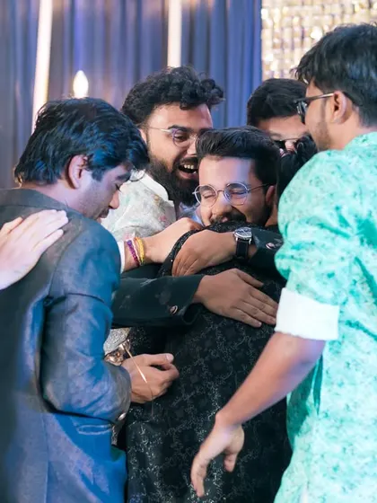 A big group hug for the groom from all his friends! A candid shot full of energy and friendship.