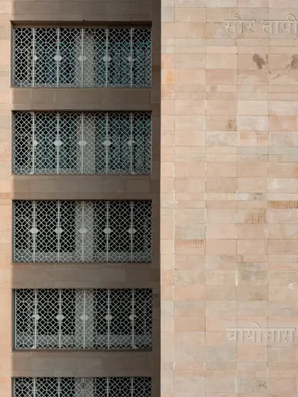 The intricate jaali screen on a stone facade is a traditional architectural practice that we use to enhance energy efficiency. It provides shade and ventilation, demonstrating how heritage can inform modern sustainable design.