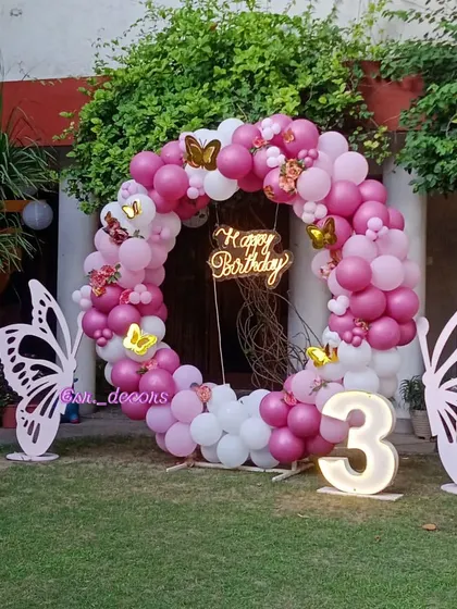 A wide shot of the beautiful garden setup for a butterfly-themed 3rd birthday, showing how our decorations complement an outdoor space.