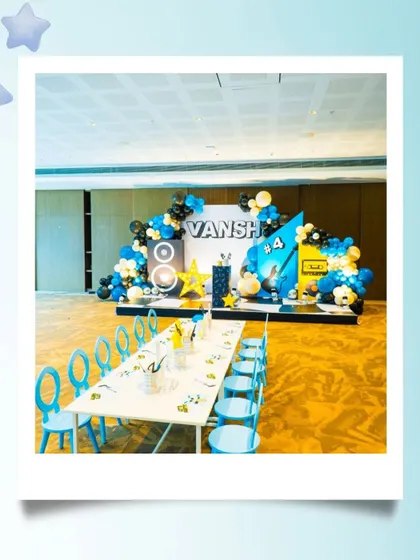 A wide shot of the rockstar-themed party for Vansh, showing the main stage, balloon arrangements, and a long table set up perfectly for the little guests to enjoy the activities.