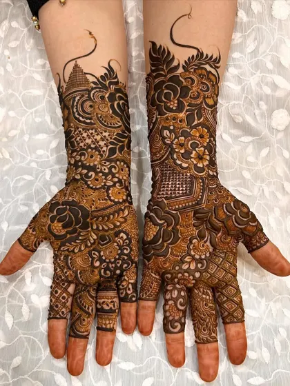 This design features a mix of architectural elements like a temple dome alongside floral patterns, creating a unique and symbolic bridal mehendi.