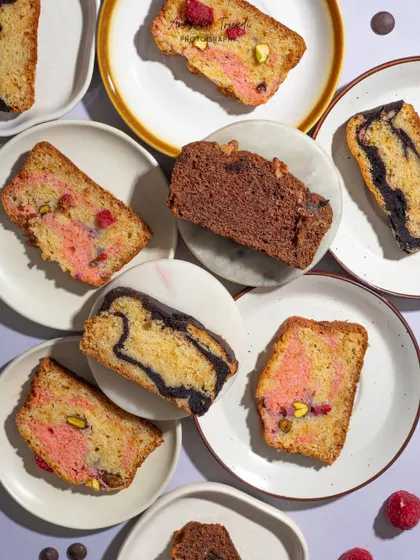 A flat lay of various marble cake slices, showcasing the different colorful swirls inside each piece.