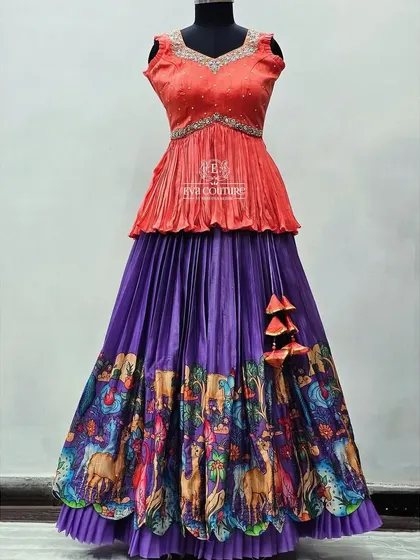 A beautiful hand-painted gown in purple and peach. The skirt features a detailed border with peacocks and camels, showcasing the artistry of the design.