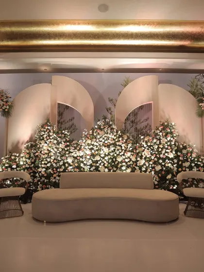 A sophisticated reception stage with curved back panels and masses of white and blush flowers.