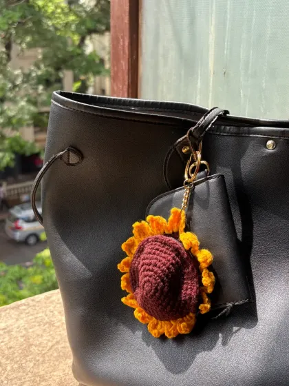 Here is the sunflower coin purse by itself, clipped to a bag. The bright yellow petals and rich brown center are designed to look just like a real sunflower.