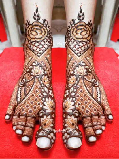 Bridal foot mehndi requires both precision and artistry. This design combines classic rose motifs with geometric patterns and delicate peacock figures, ensuring the bride looks stunning from head to toe.