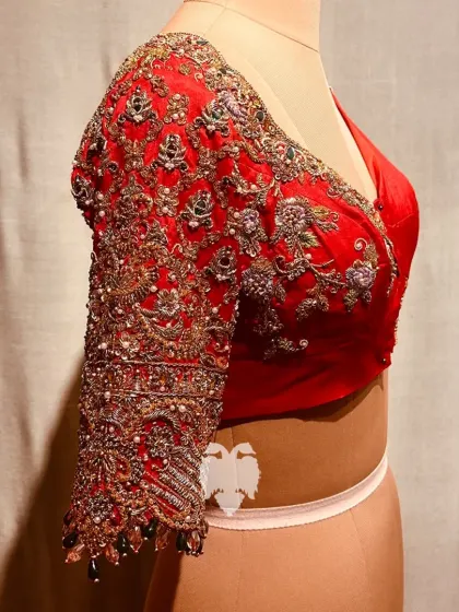 A side view of the elephant procession blouse, highlighting the heavily embroidered sleeves.