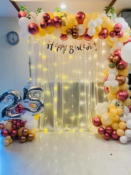 A closer view of the elegant 25th birthday balloon arch and fairy light backdrop.