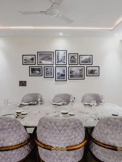 A straight-on view of the dining table, with a gallery wall of black and white photos creating a personal and artistic focal point.