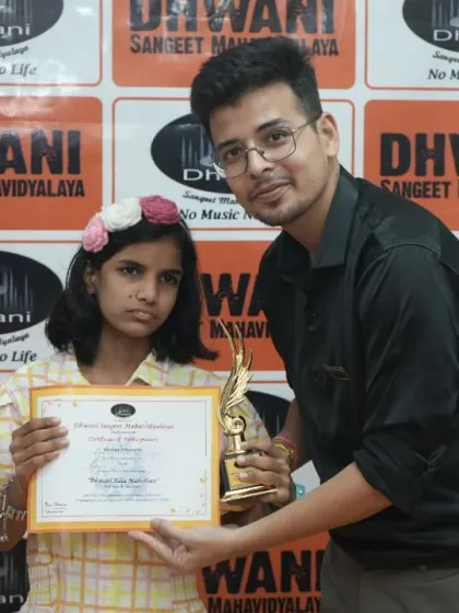 A teacher presents an award to his student.