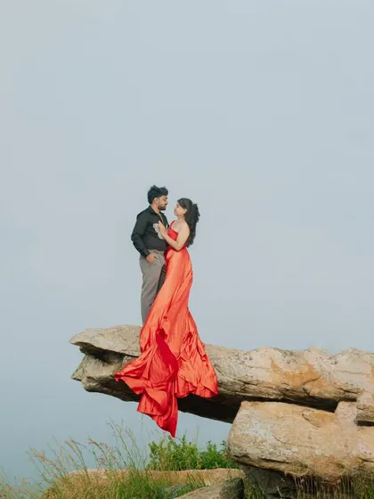 Another breathtaking clifftop pose, showcasing the dramatic beauty of the location and the outfits.