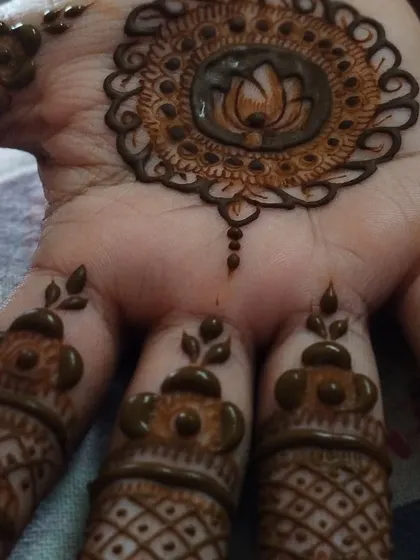 A close-up of the lotus mandala, showing the fine details in the center and the delicate patterns on the fingers.