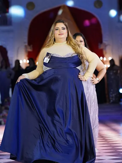 A beautiful plus-size model in a royal blue satin gown. The simplicity of the design is elevated by the luxurious fabric and perfect fit.