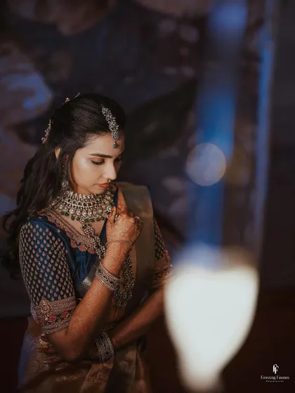 A moody portrait of the bride, with a single candle flame illuminating her face.