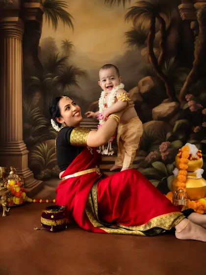 A playful and energetic shot of a mother and her standing baby Krishna.
