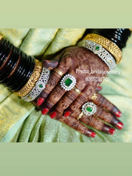 A detailed shot of the bride's hands, showing the matching AD bangles and statement rings with green stones.