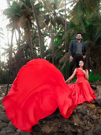 A scene straight out of a movie. The massive, flowing red trail of the gown creates an incredible visual, making this couple's pre-wedding shoot absolutely epic.