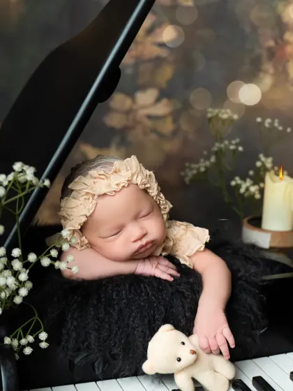 A detailed close-up of the newborn on the piano, holding a tiny teddy bear. I focus on capturing these small, heartwarming details that make each photo special.