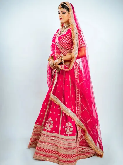The full view of this stunning pink Marvadi bridal lehenga, showcasing its beautiful flare and detailed border work.