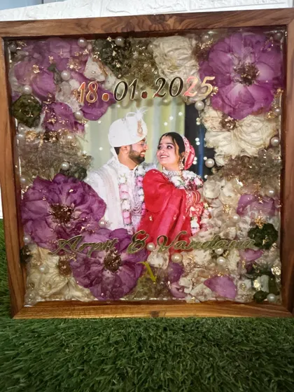 An angled shot of a varmala frame, highlighting the depth and dimension created by layering the flowers in clear resin. The details are sealed perfectly under a glossy finish.