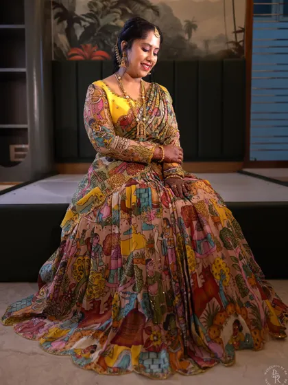 A full-length portrait showcasing the incredible artistry of the Kalamkari lehenga worn for a housewarming. It’s a celebration of both a new home and wearable art.
