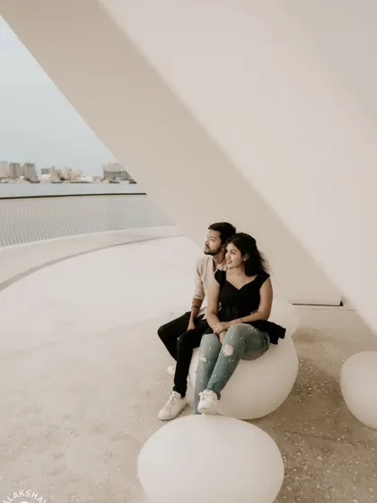 A happy, relaxed moment for the couple sitting on modern, orb-like seats.
