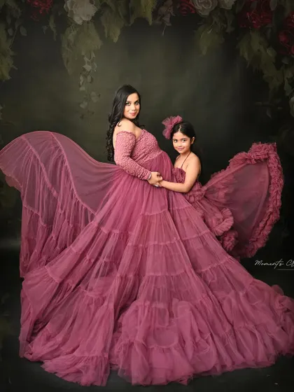 A magical mother-daughter portrait. The matching mauve gowns and the flowing fabric create a stunning, fairytale-like image that celebrates their special bond.