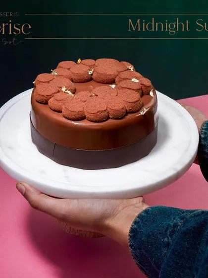 Holding the Midnight Sun, ready to be served. This cake is one of my signature creations, a testament to the timeless combination of chocolate and caramel.