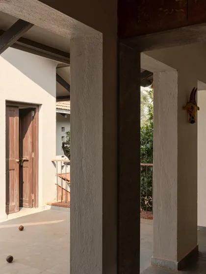 A view through the columns on the veranda of Maison Rouge, capturing the play of light and shadow.