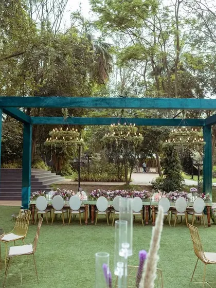 A wider perspective of the outdoor dining area, showing the arrangement of tables and the main dining structure against the backdrop of lush trees and the nearby lake.