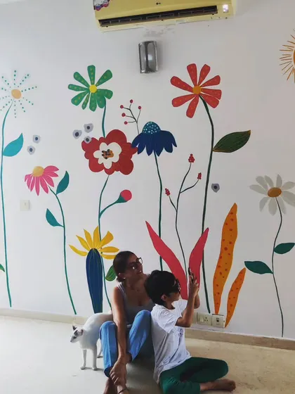 The client and her son enjoying the new floral mural, with their cat making an appearance. It's wonderful to see families enjoying the art.