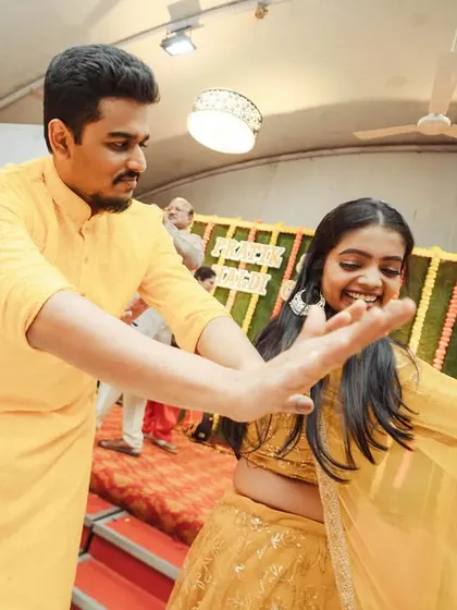 A wide-angle shot capturing the movement and fun of the Haldi dance. The energy is palpable.